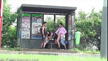 A guy is sharing a girlfriend with his friend at a bus stop